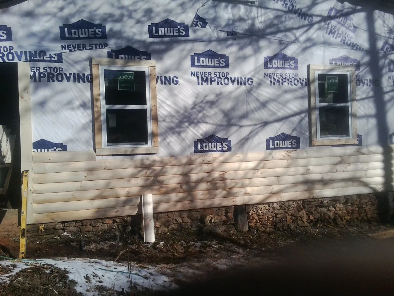 House wrap and new log siding going up on an exterior wall in Elk Grove