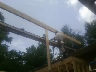Carpenter setting a ridge beam over a new addition frame — Ice Dam Removal by Roofing Brothers in Elk Grove