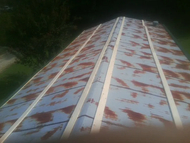 Rusted metal roof panels with new wood purlins before replacement — Storm Damage Roof Repair in Elk Grove by Roofing Brothers